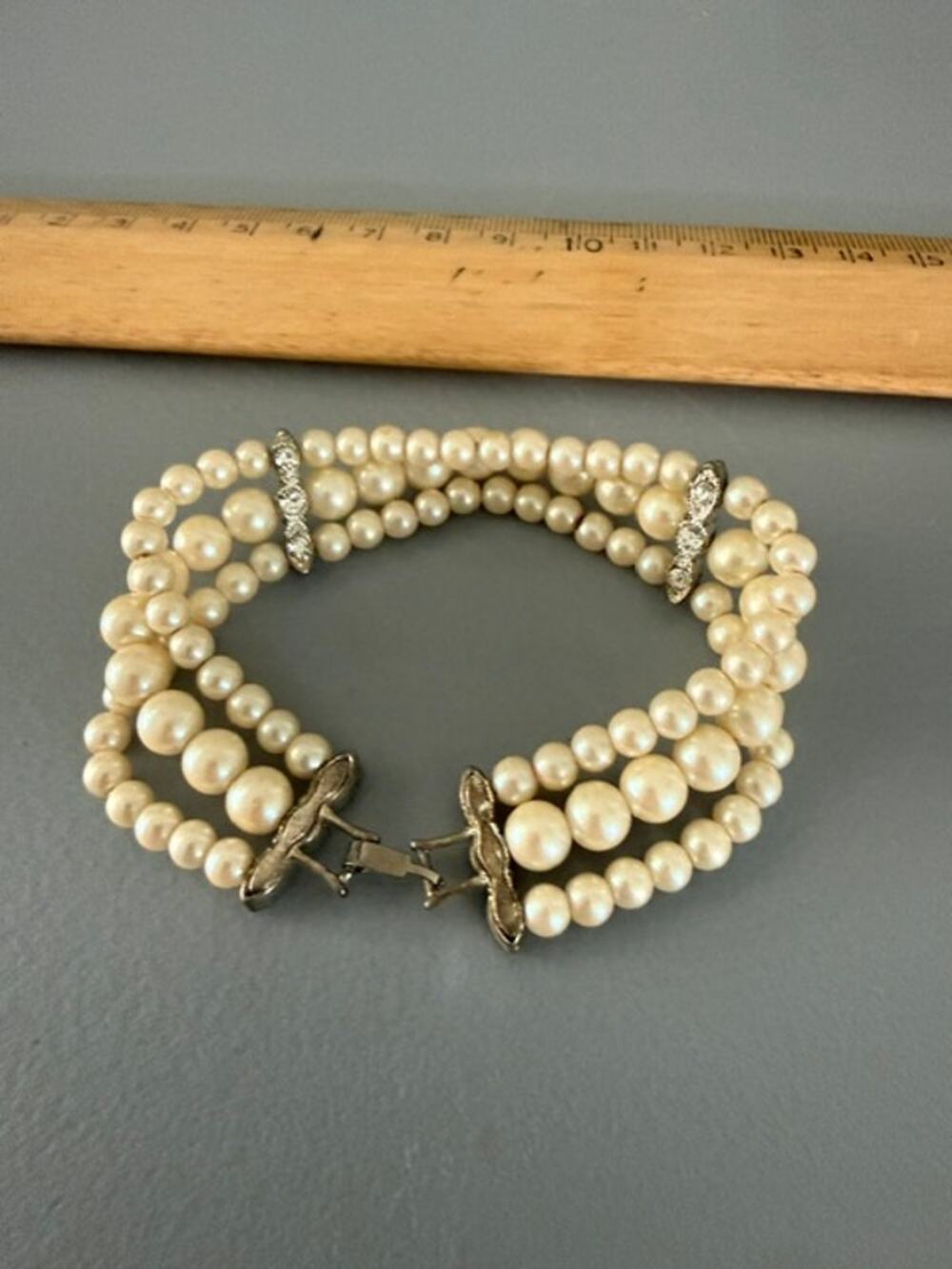 Vintage bracelet three strands pearls W/rhinestone clasps.